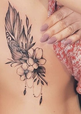 Tatouage plume avec deux fleurs sur les côtes